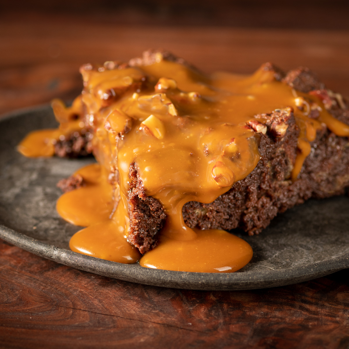 Plate of chocolate bread pudding with salted caramel sauce drizzled on top.