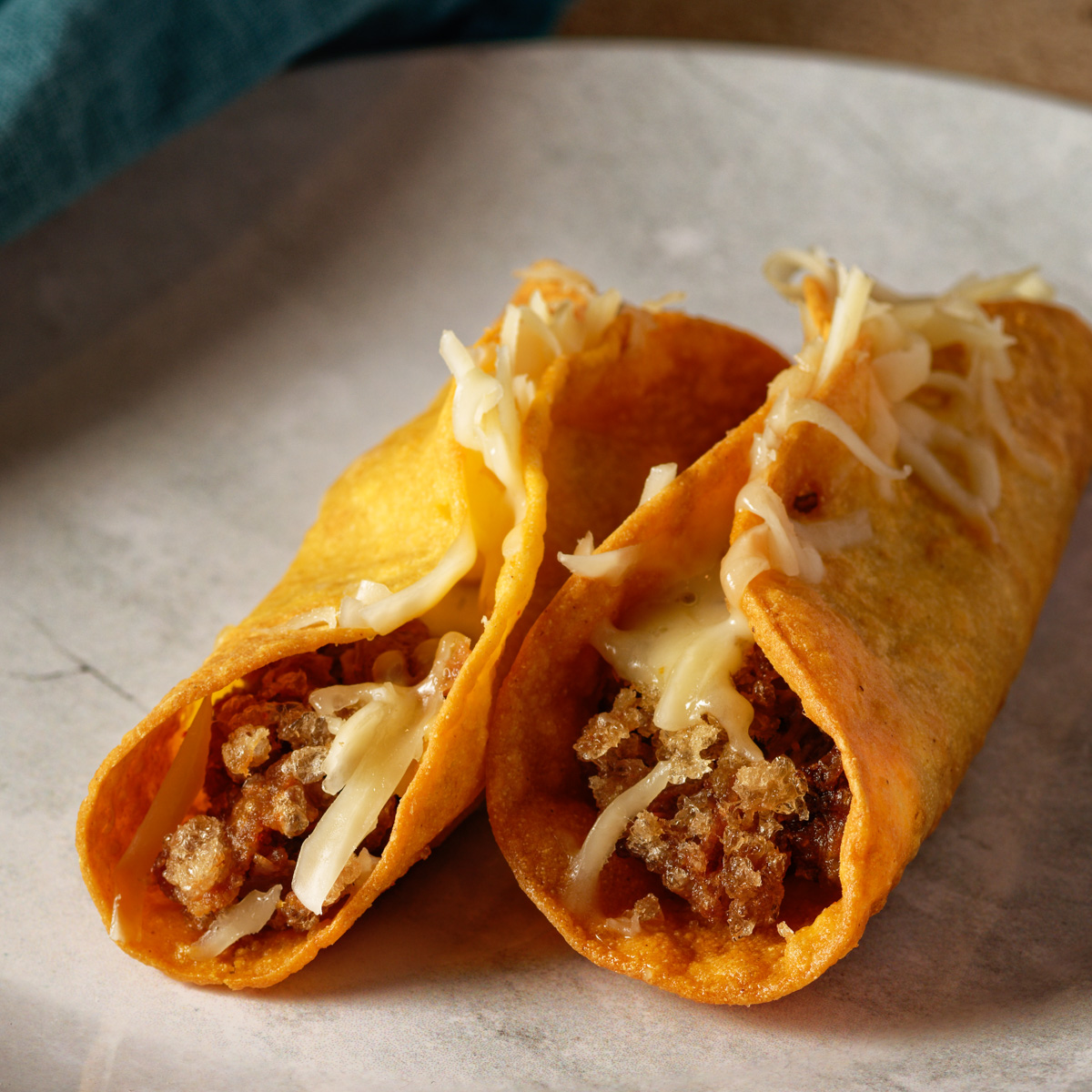 Two deep fried tacos with crispy carnitas filling.