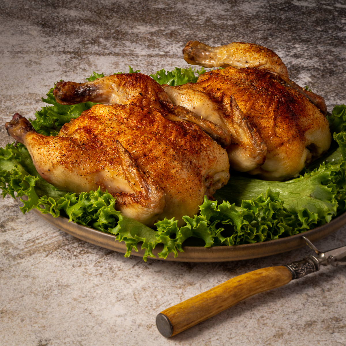 Two roasted cornish hens on a plate.