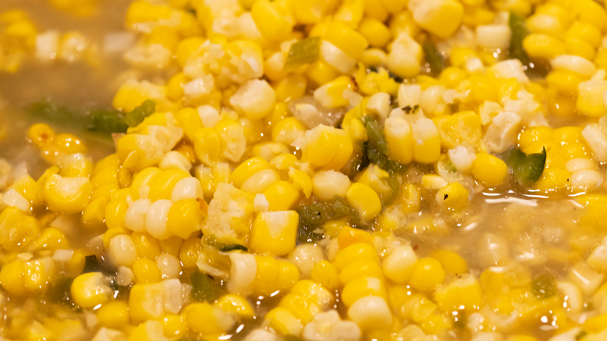 Mix the corn with the poblano pepper and chicken stock.