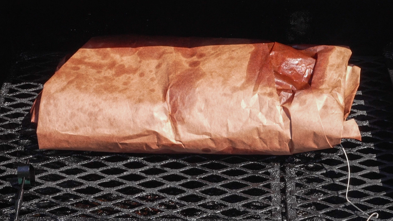 Brisket in Smoker Wrapped in Butcher Paper