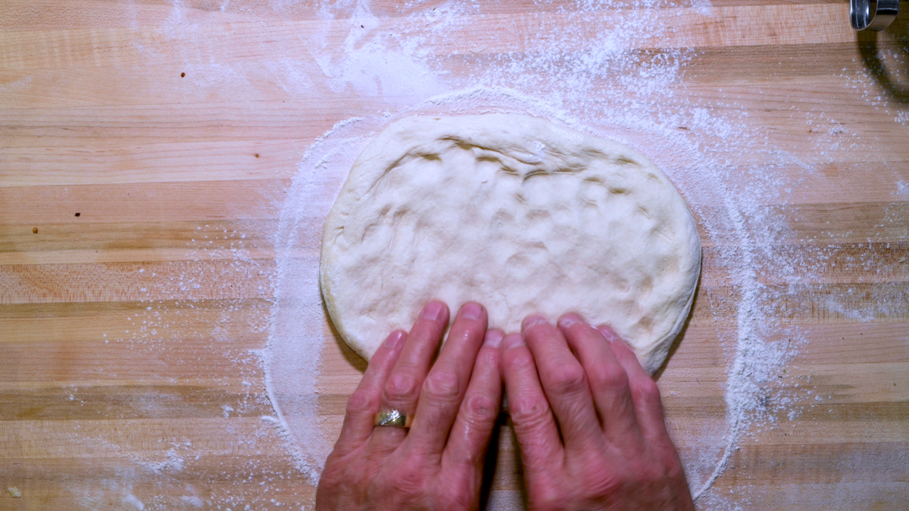 Press Down With Your Fingertips From the Center Outward to Stretch the Dough