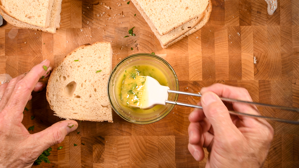 Preparing to butter garlic bread