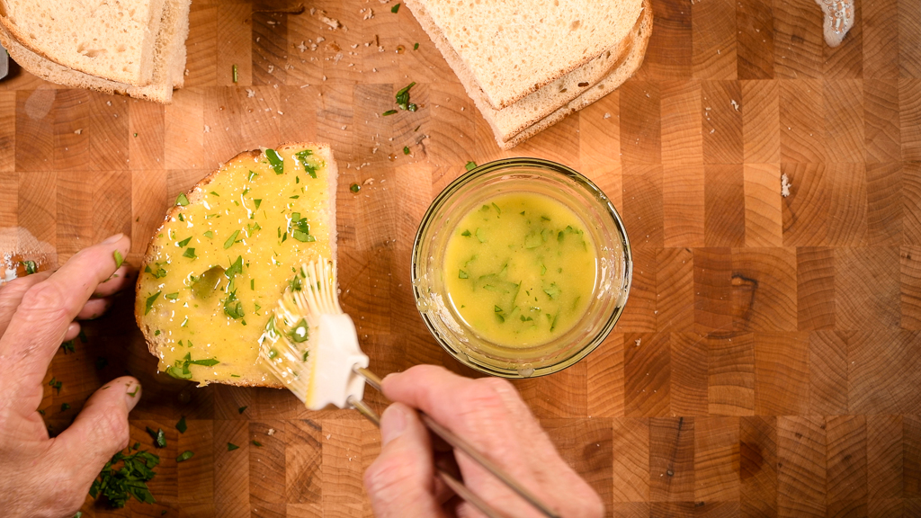 Spreading garlic butter on bread