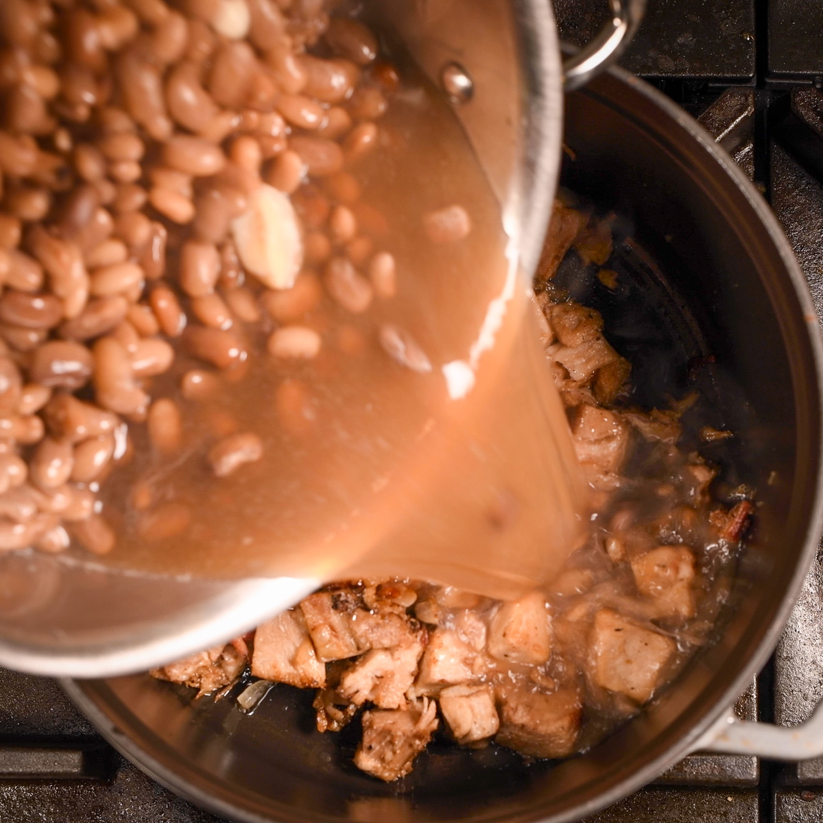 Add beans to carnitas, onion and bacon.