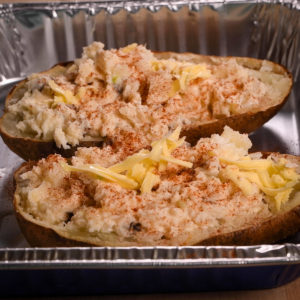 Top potatoes with cheddar cheese and bake inside the grill.
