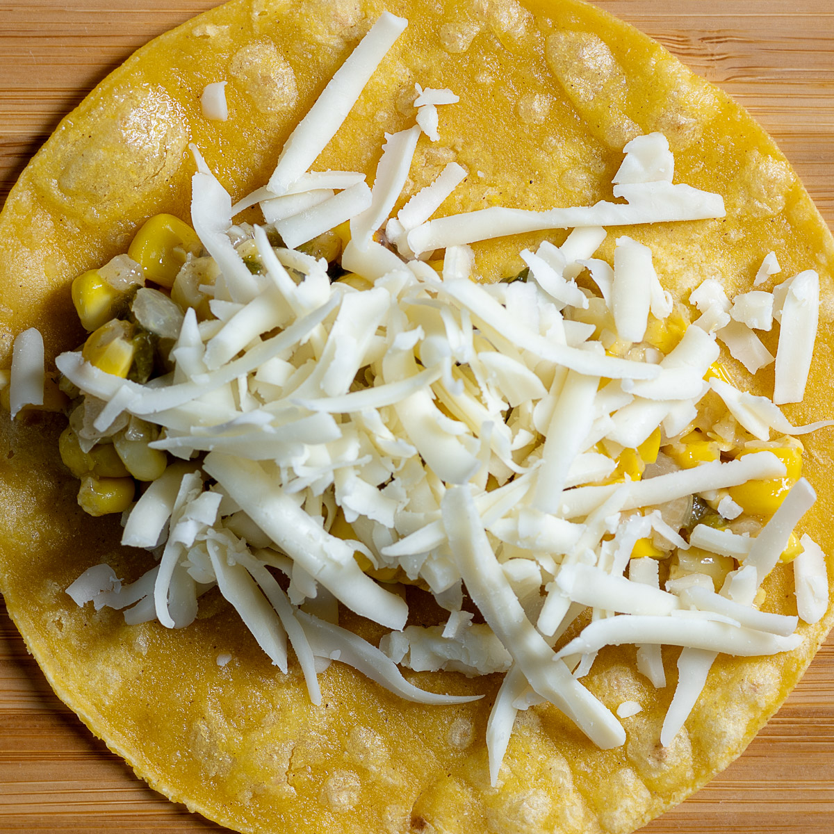 Add grated cheese to the enchilada.