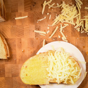 Add shredded cheese on top of the sourdough.