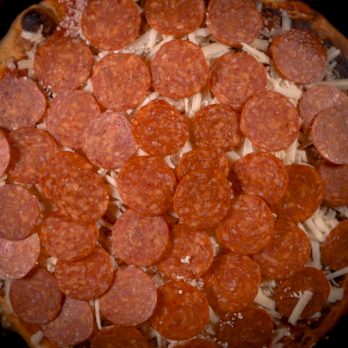 Add a layer of pepperoni on top of the cheese.