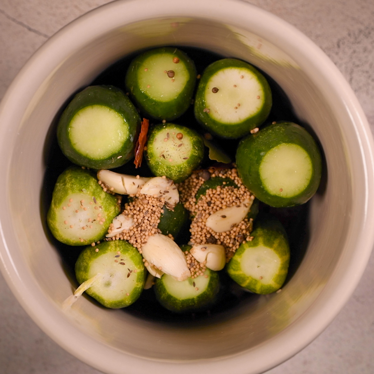 Add pickling spice and garlic to the pickling crock.