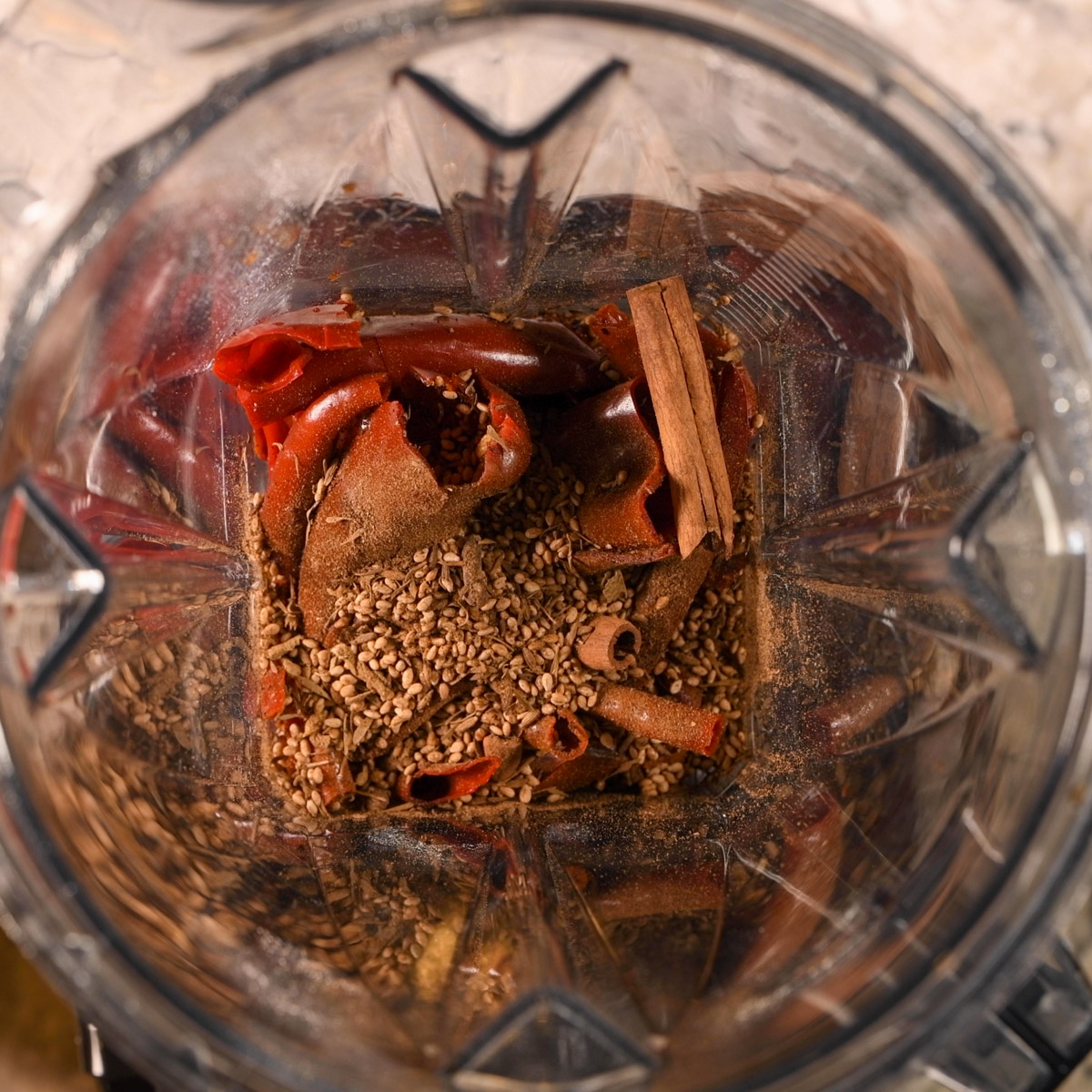 Add the soaked chiles and toasted spices to a blender.