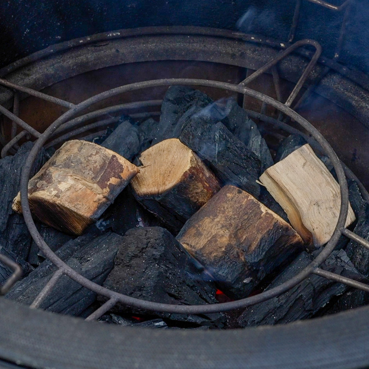 Add wood chunks to lit charcoal.