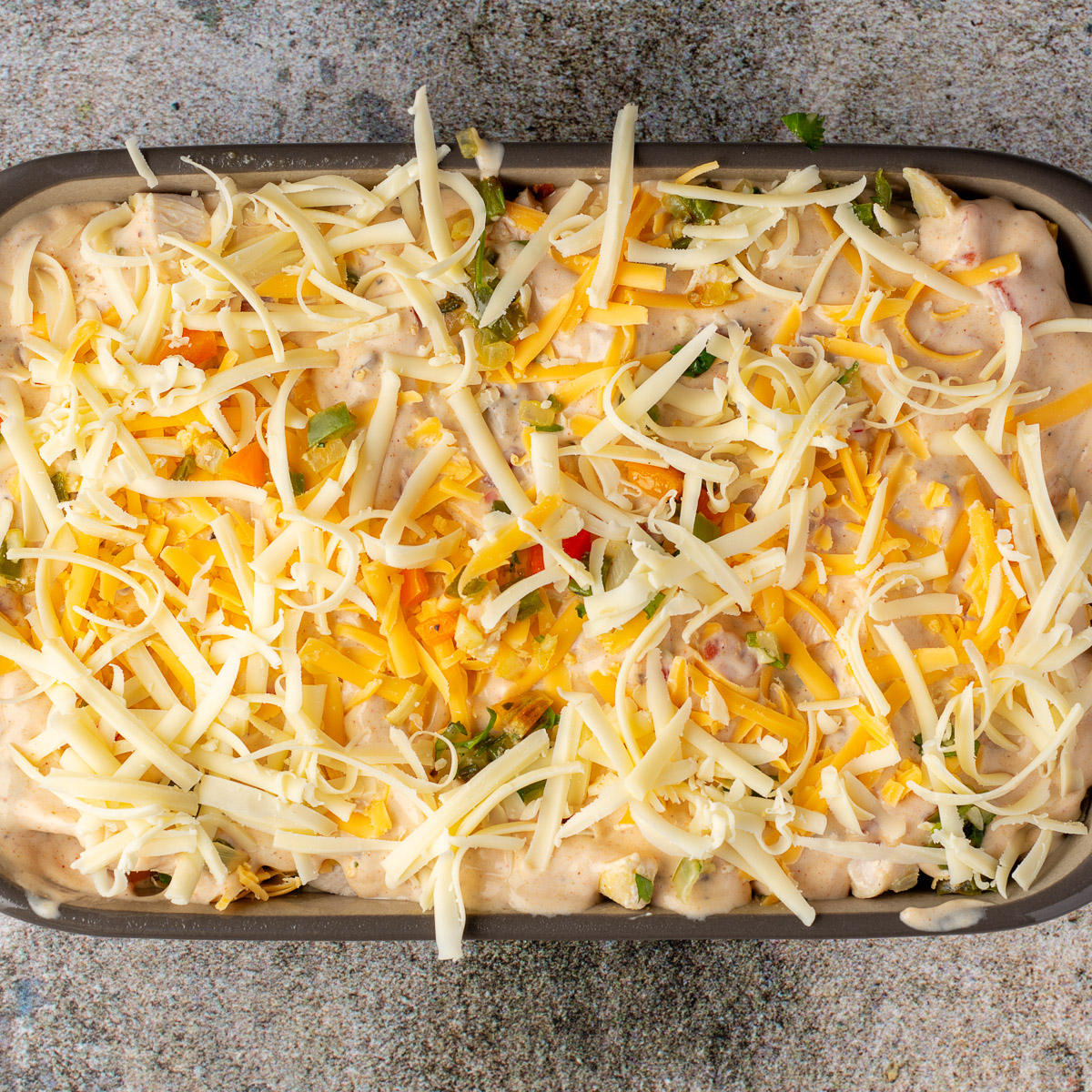 Add layers of tortillas, chicken, soup and cheese in a large casserole dish.