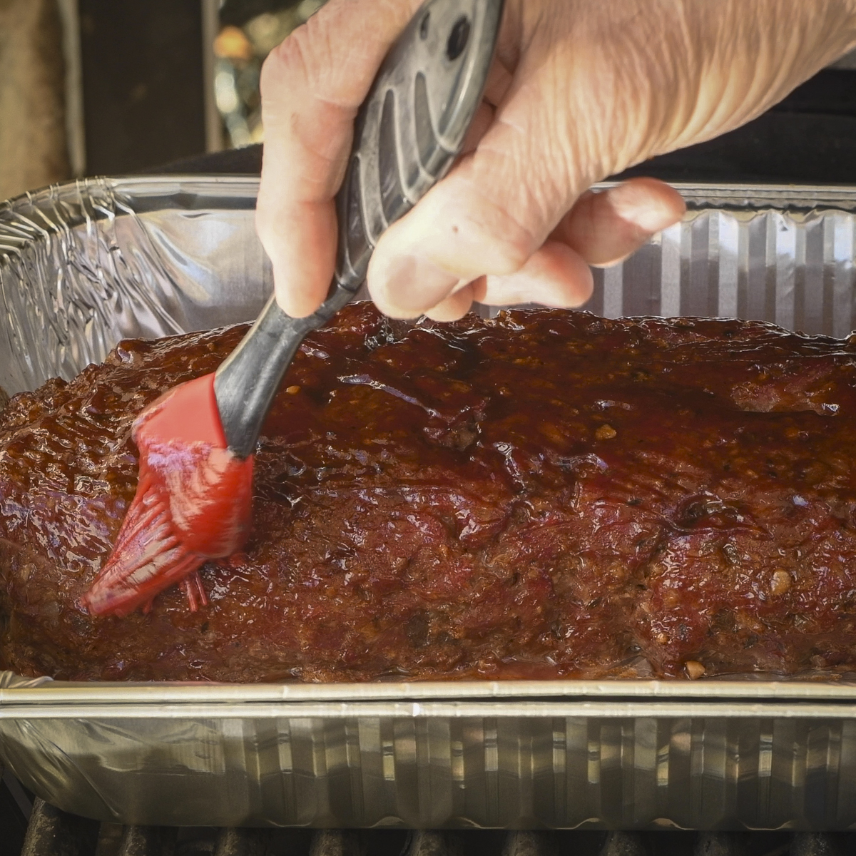 Brush the meatloaf with the BBQ sauce glaze.