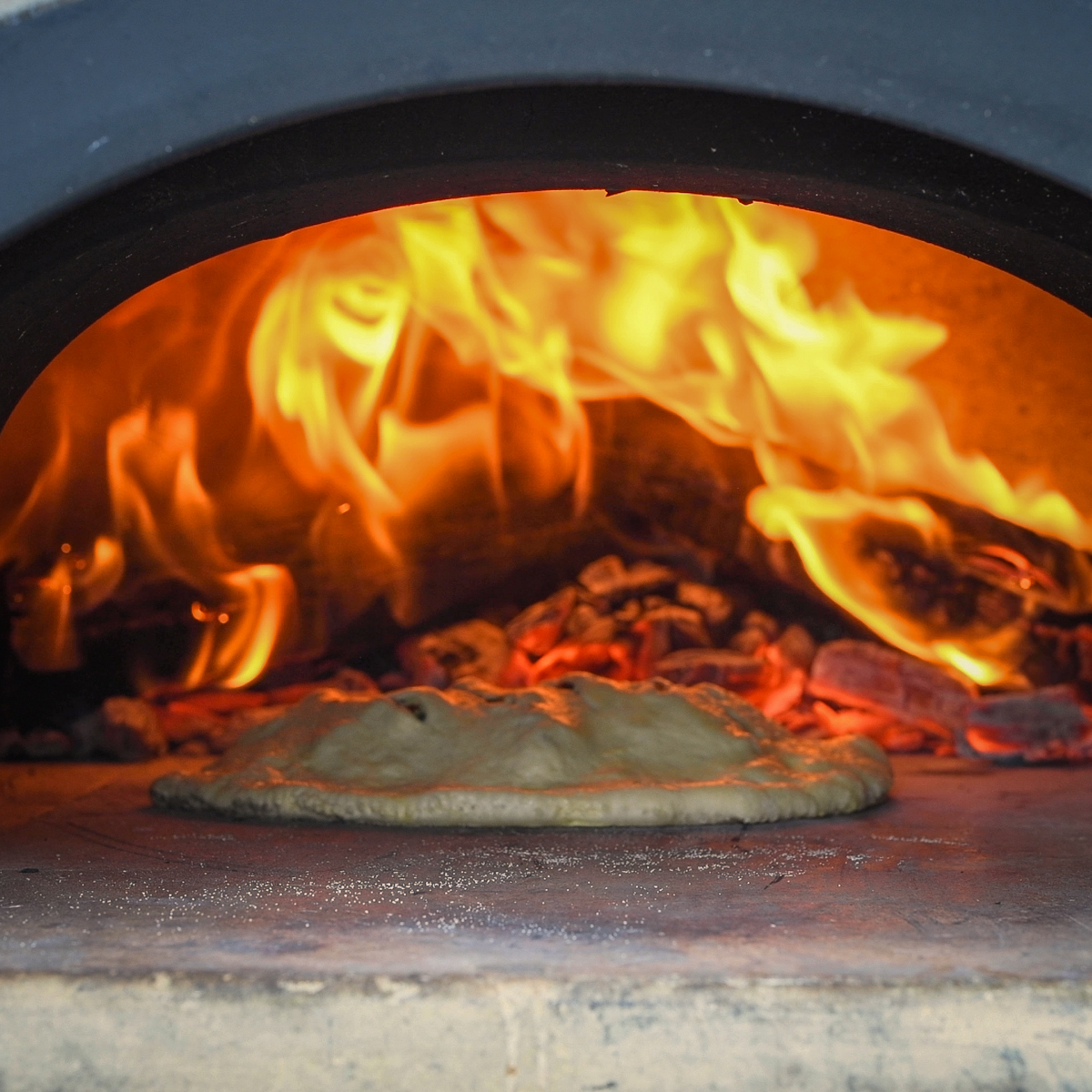 Calzone cooking in a pizza oven.