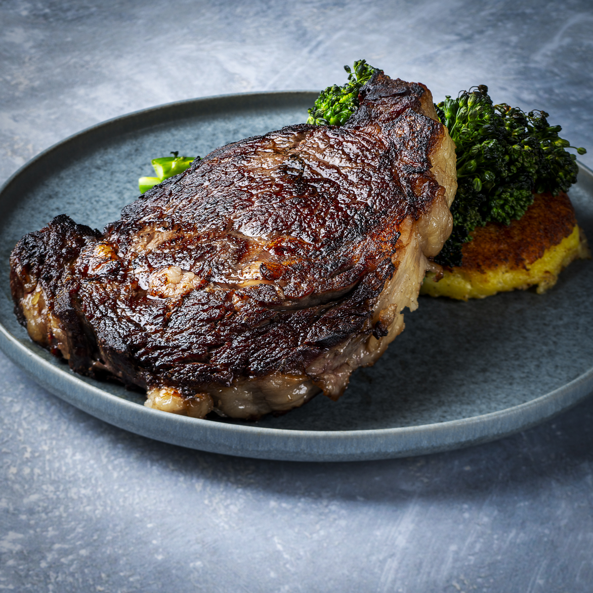 Cooked ribeye steak on a plate.