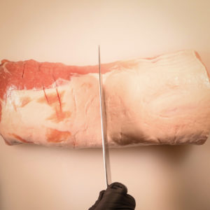 Cutting a 5 pound pork loin in half.