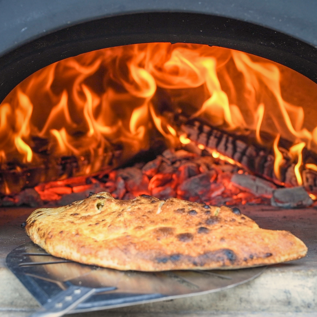 Calzone coming out of a pizza oven.