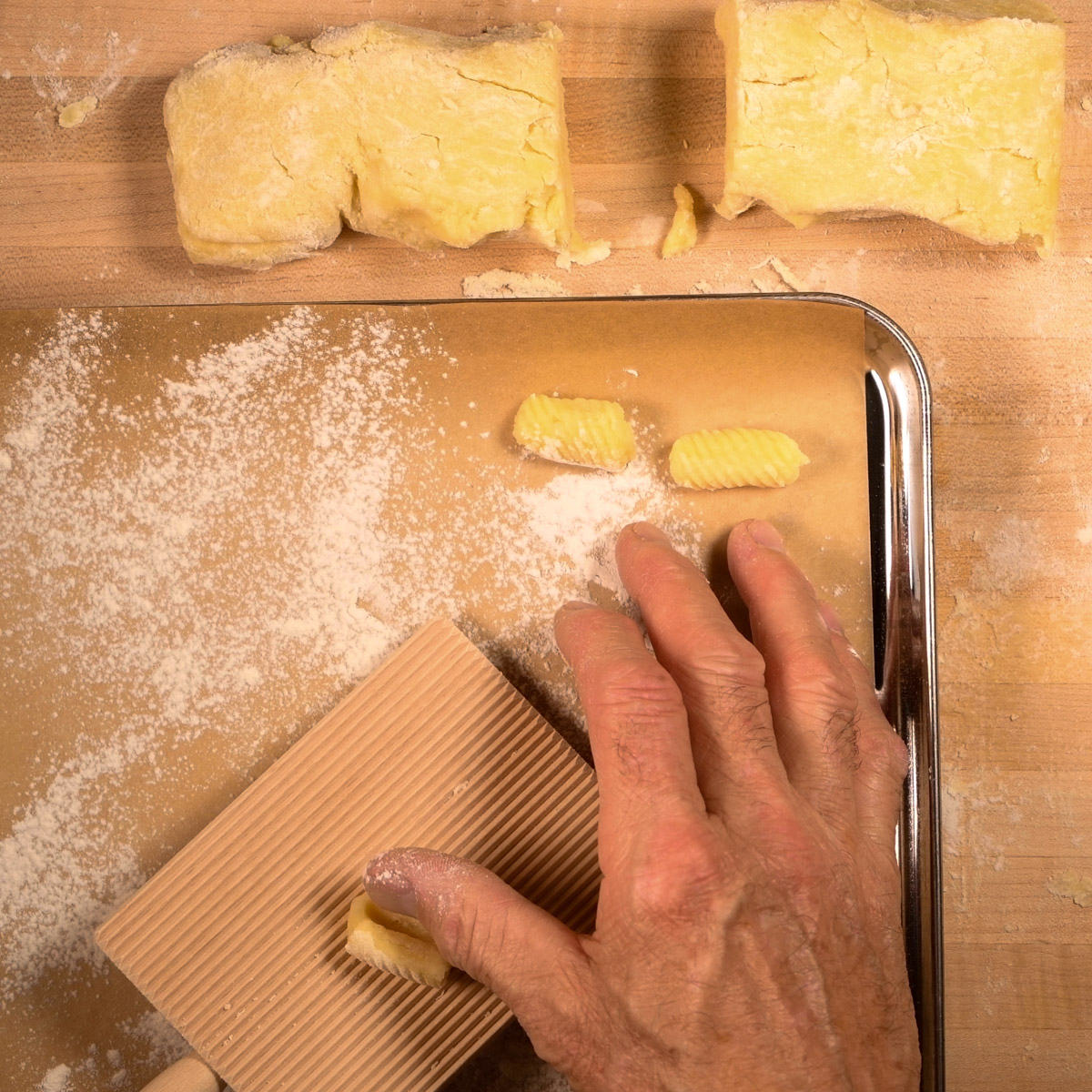 Roll each piece of dough across a gnocchi board.
