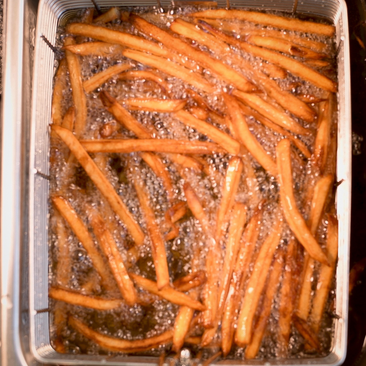 Add the Wagyu beef tallow to the hot oil and fry the potatoes a second time.