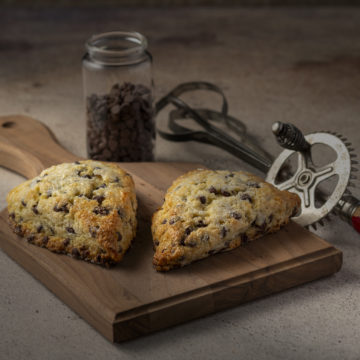 Chocolate-chip-scones on a wood board.