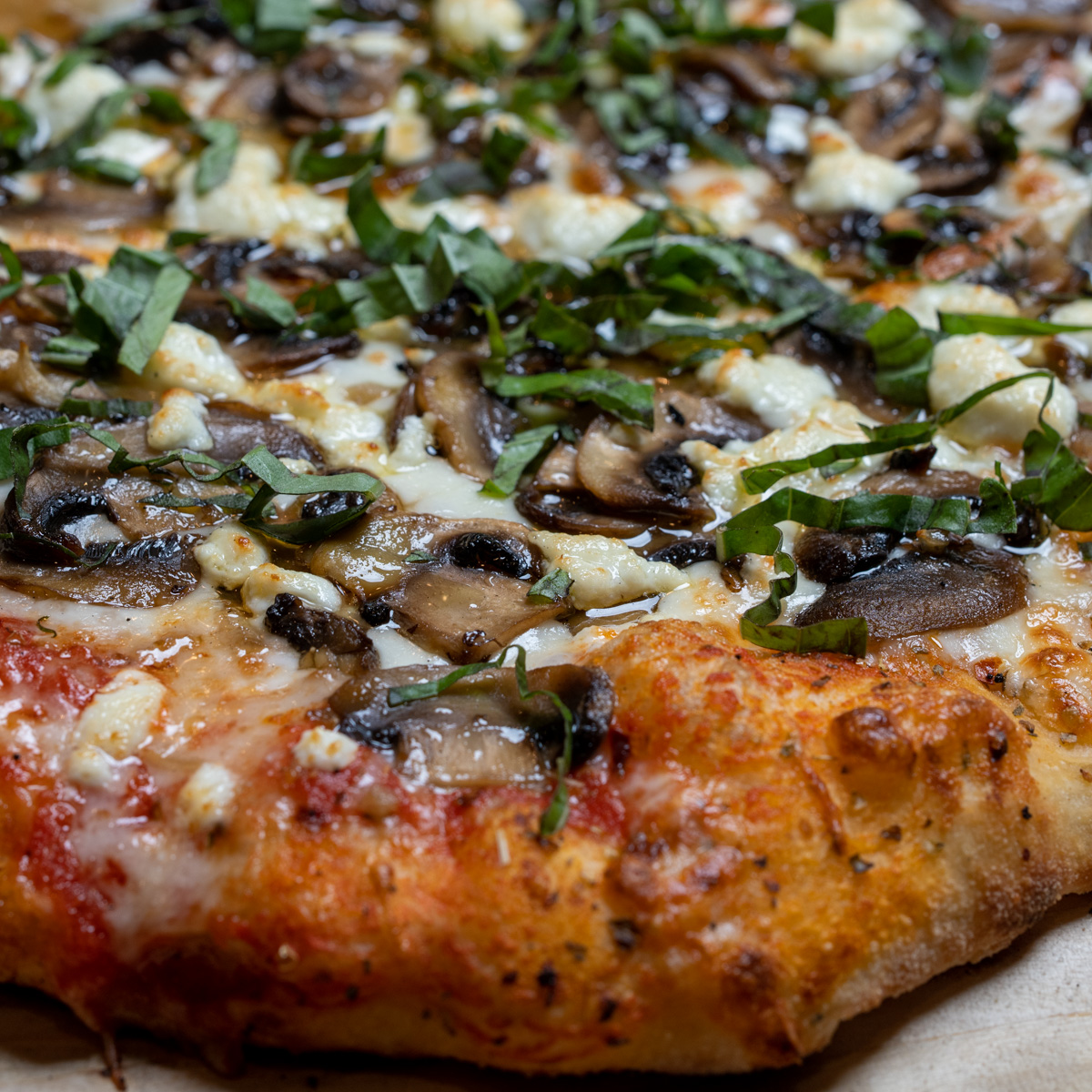 Mushroom pizza with goat cheese, fresh basil and finished with a drizzle of truffle oil.