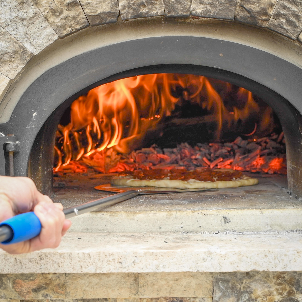 Pepperoni pizza in a wood-fired oven.