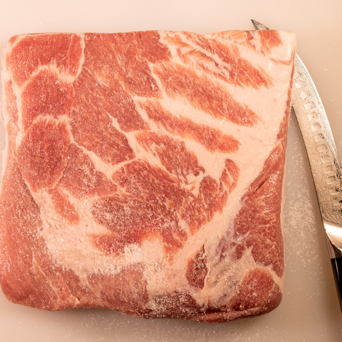 Trim excess fat from the pork shoulder.
