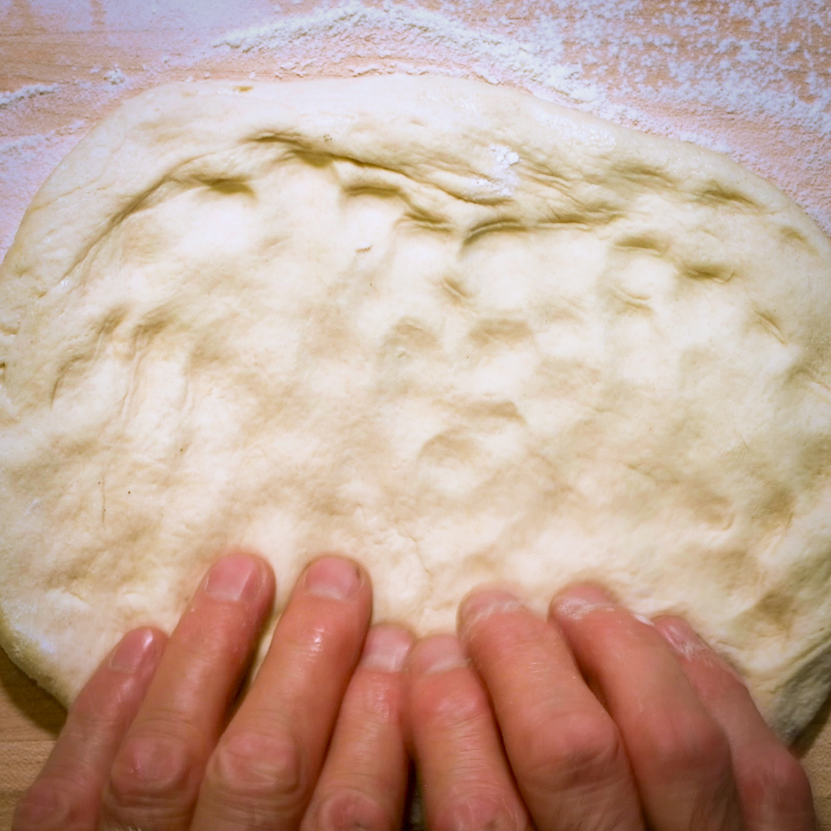 Flatten pizza dough into a disc.