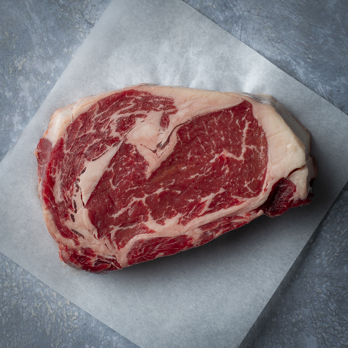 Raw double-cut ribeye steak.