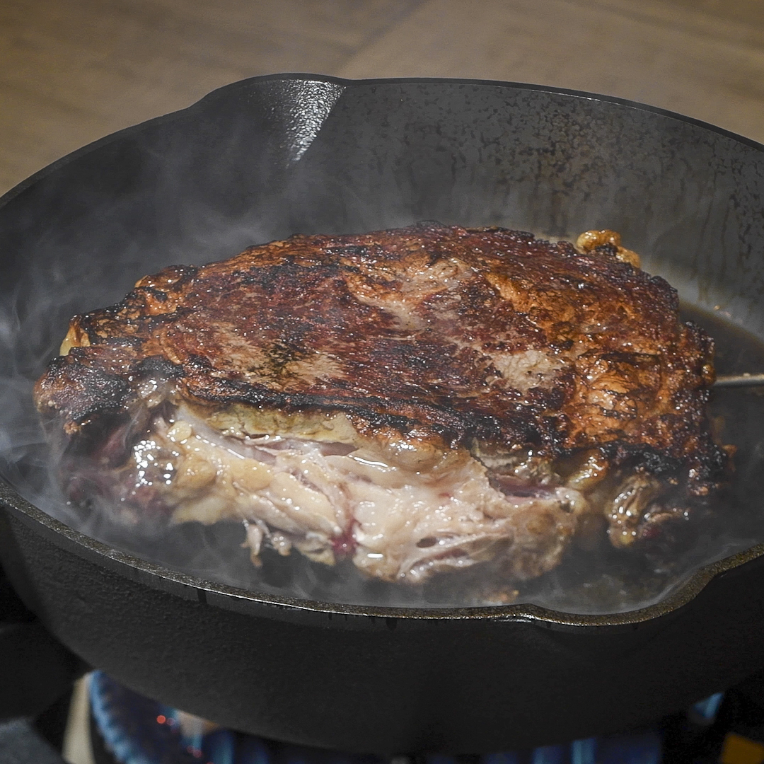 Seared ribeye in a cast-iron skillet.