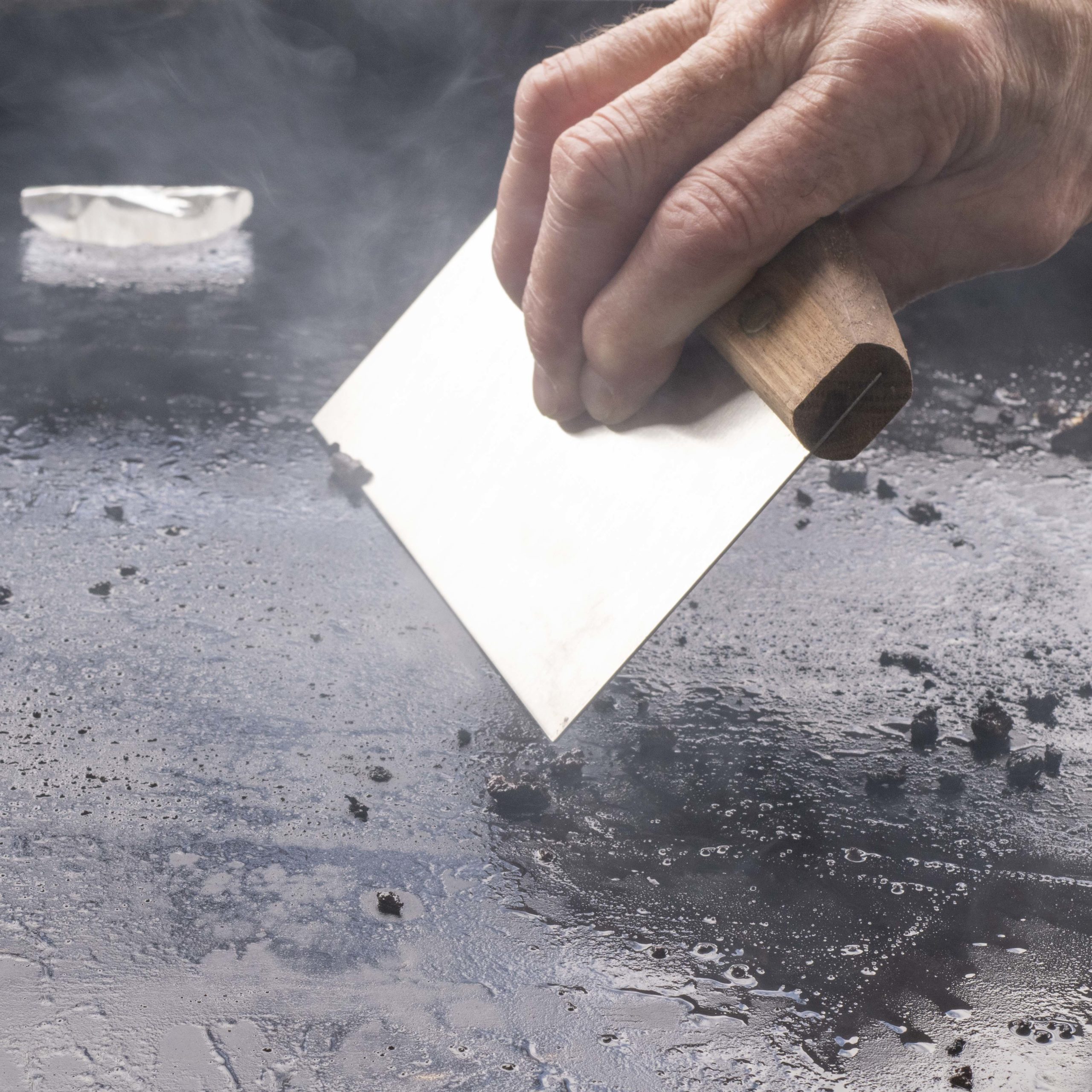 Scrape the griddle with a bench scraper.