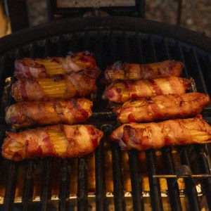 Cook the bacon-wrapped stuffed shells in a smoker.
