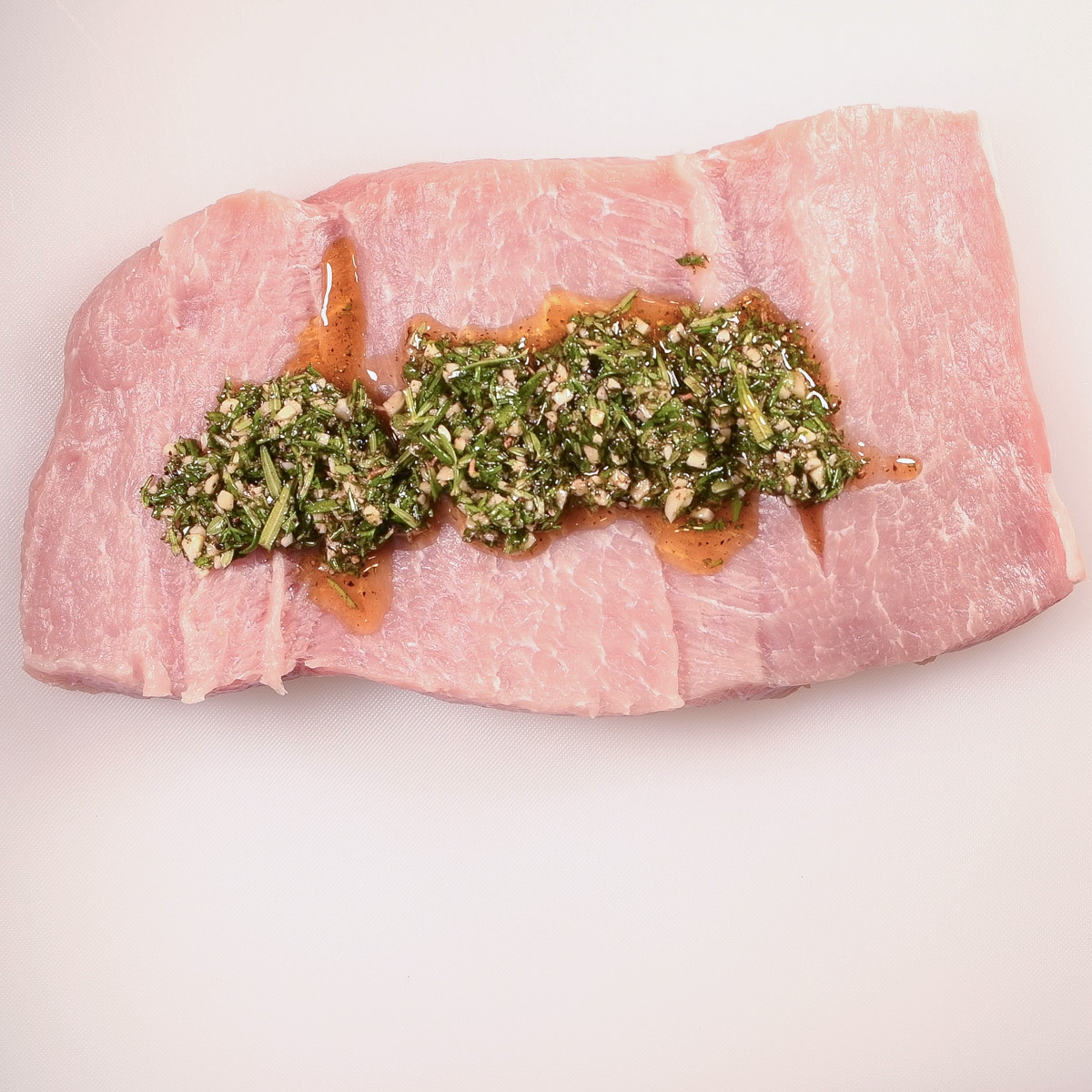 Add the herb mixture to the center of the butterflied pork loin.