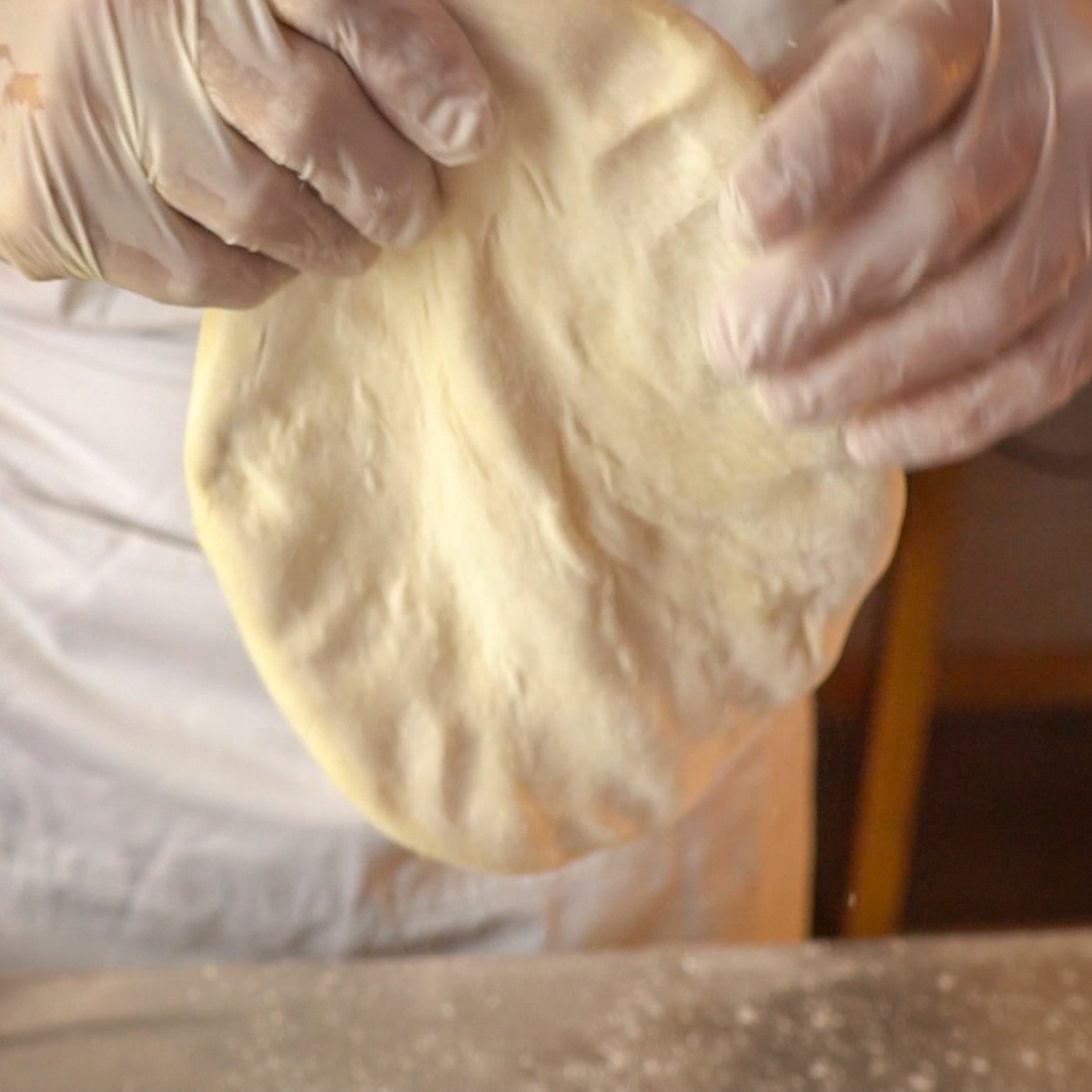 Stretch the pizza dough by hand.