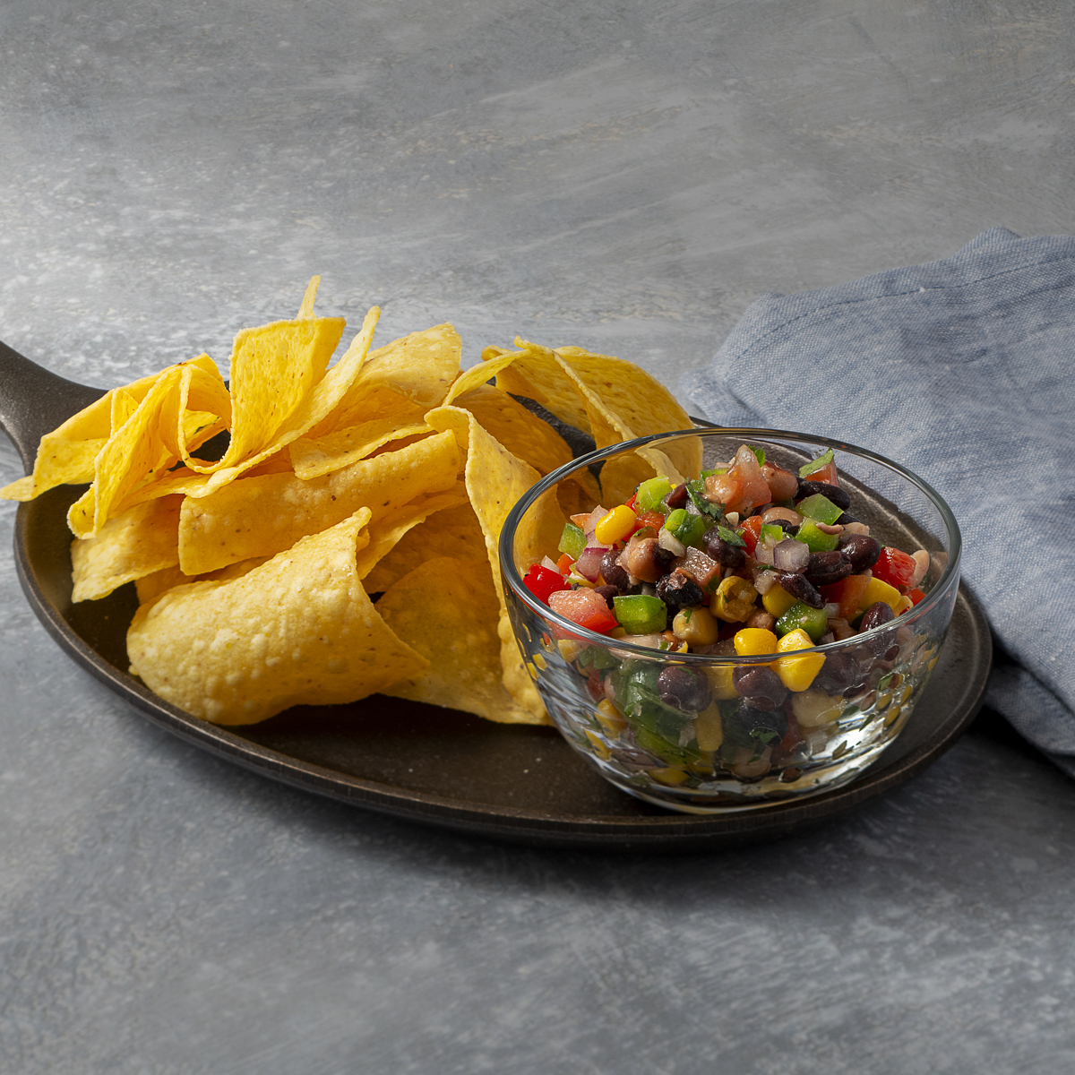 Bowl of Texas caviar with a side of warm tortilla chips.