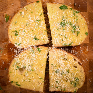 Sprinkle freshly grated parmesan cheese over the garlic butter.