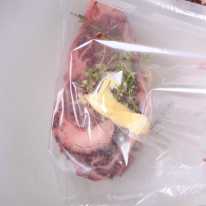 Dry aged ribeye sealed in a sous vide bag.